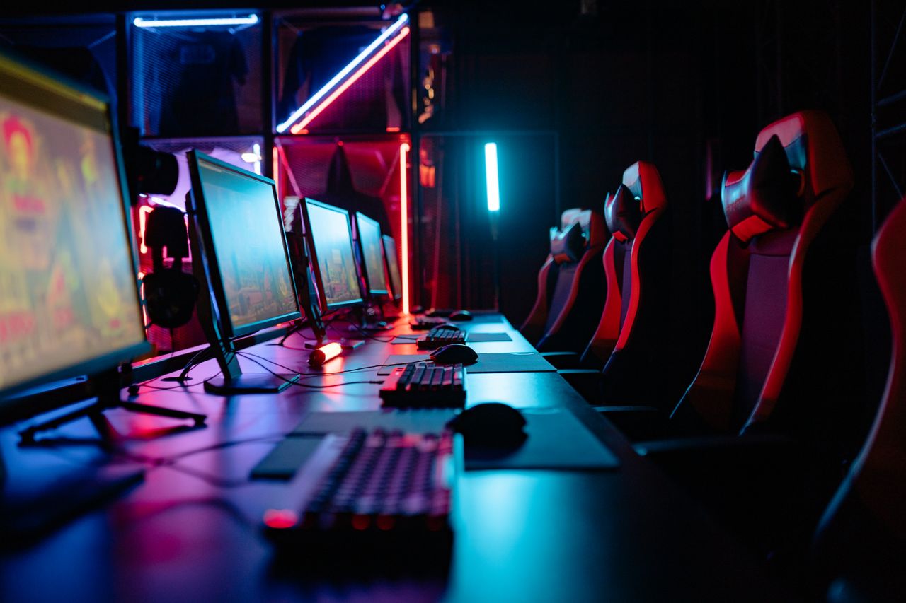 Home An immersive gaming room with neon lights, computers, and gaming chairs ready for a tournament.